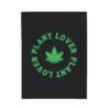 This plant lover weed leaf blanket features a bold weed leaf design with 'Plant Lover' written around it, all in a green color same as the weed leaf itself. Weed Leaf blanket is black.