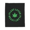 This plant lover weed leaf blanket features a bold weed leaf design with 'Plant Lover' written around it, all in a green color same as the weed leaf itself. Weed Leaf blanket is black.