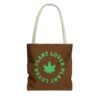 This plant lover weed leaf tote bag features a bold weed leaf design with 'Plant Lover' written around it, all in a green color same as the weed leaf itself. Weed Leaf Tote Bag is brown