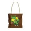 This Lemon Kush tote bag features two weed leaves two lemons standing on boxes squirting lemon juice on weed plants like they are peeing on them. "Lemon Kush is written above the lemons with a green background.